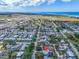 Aerial view of a residential community, with houses, streets, and trees, under a partly cloudy sky at 938 The Rialto, Venice, FL 34285