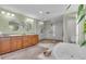 Modern bath showcasing a glass shower, garden tub, granite counters and wood cabinetry at 938 The Rialto, Venice, FL 34285