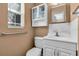 Functional bathroom with a classic white toilet and vanity setup, naturally illuminated by a window at 938 The Rialto, Venice, FL 34285