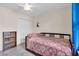 Bedroom featuring ceiling fan, tile flooring, and plush rug with view to the window at 938 The Rialto, Venice, FL 34285