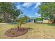 Charming, two-story turquoise home with a well-manicured lawn and mature landscaping in a tropical setting at 938 The Rialto, Venice, FL 34285