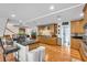 Bright, open-concept kitchen with wood floors, cabinetry and dark countertop island with barstool seating at 938 The Rialto, Venice, FL 34285