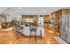 Open kitchen with stainless steel appliances, a wine rack, and an island with bar stool seating at 938 The Rialto, Venice, FL 34285