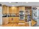 Updated kitchen with stainless steel appliances, wood cabinetry, and a wine rack at 938 The Rialto, Venice, FL 34285
