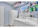 Well-lit laundry room equipped with a washer, dryer, and additional storage at 938 The Rialto, Venice, FL 34285