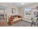 Bright living room features a wicker couch and a window overlooking the outdoor landscape at 938 The Rialto, Venice, FL 34285