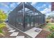 Backyard view featuring an enclosed pool with patio, outdoor seating and lush tropical foliage at 938 The Rialto, Venice, FL 34285