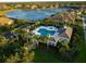 An aerial perspective shows a luxury pool and spa surrounded by perfectly manicured landscaping in an upscale community at 27336 Driver Ln, Englewood, FL 34223