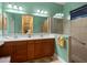 Bathroom featuring a double vanity, walk-in shower, and neutral tiling at 27336 Driver Ln, Englewood, FL 34223