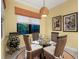 Bright breakfast nook with a glass table, woven chairs, pendant lighting, and a modern wine rack at 27336 Driver Ln, Englewood, FL 34223