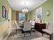 Spacious dining room featuring neutral tones, a chandelier, and large windows for natural light at 27336 Driver Ln, Englewood, FL 34223