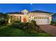 Charming single-story home featuring a red tile roof, lush landscaping, and a brick paver driveway at 27336 Driver Ln, Englewood, FL 34223