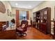 This home office features hardwood floors, a dark wood bookcase, and a comfortable leather executive chair at 27336 Driver Ln, Englewood, FL 34223