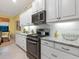 Updated kitchen features white cabinets, stainless steel range, and light granite countertops at 27336 Driver Ln, Englewood, FL 34223