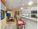 Open kitchen featuring white cabinets, granite countertops, stainless steel appliances, and a breakfast bar with seating at 27336 Driver Ln, Englewood, FL 34223
