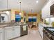 Open kitchen with white cabinets, granite counters, stainless appliances, and a view of the adjacent breakfast nook at 27336 Driver Ln, Englewood, FL 34223