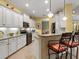 Modern kitchen with white cabinetry, stainless steel appliances, a breakfast bar, and recessed lighting at 27336 Driver Ln, Englewood, FL 34223
