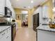 Updated kitchen featuring white cabinetry, stainless steel appliances, granite countertops, and tile flooring at 27336 Driver Ln, Englewood, FL 34223