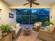 Outdoor lanai featuring wicker furniture, a fountain, and picturesque landscaping at 27336 Driver Ln, Englewood, FL 34223