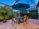 Lanai with a dining table and comfortable seating beneath the shade of an umbrella at 27336 Driver Ln, Englewood, FL 34223