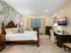 Spacious main bedroom featuring a decorative accent wall, plush carpet, and a cozy sitting area at 27336 Driver Ln, Englewood, FL 34223