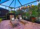 Covered patio features two lounge chairs with throw pillows and string lights creating a relaxing outdoor space at 27336 Driver Ln, Englewood, FL 34223