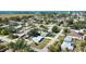 Aerial view of a residential neighborhood featuring lush greenery and the charming light blue home at 100 Aurora W St, Venice, FL 34285