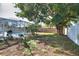 Lush backyard with mature trees, patio furniture, and a screened pool, ideal for outdoor entertaining at 100 Aurora W St, Venice, FL 34285