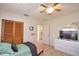 Bright bedroom features tiled floors, wooden closet doors, ceiling fan and natural light at 100 Aurora W St, Venice, FL 34285