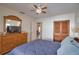 Bedroom featuring wood dresser, tiled floors, ceiling fan, and natural light at 100 Aurora W St, Venice, FL 34285