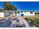 Welcoming exterior of a cozy home with large trees, a driveway, and a screened lanai at 100 Aurora W St, Venice, FL 34285