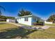 Charming home with green grass, a walkway, mature plants and a long driveway at 100 Aurora W St, Venice, FL 34285