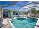 Sparkling swimming pool with screened enclosure offers privacy and a refreshing escape at 100 Aurora W St, Venice, FL 34285