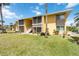 Exterior of a yellow two-story building with well-maintained lawn and mature palm trees at 101 Louella Ln # 11, Nokomis, FL 34275