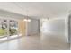 Bright living room with tile flooring, sliding glass doors to the outside, and a modern chandelier at 101 Louella Ln # 11, Nokomis, FL 34275