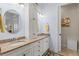 Bathroom showcases double sinks, granite countertops, central linen cabinet, and a decorative accent rug at 11026 Barnsley Dr, Venice, FL 34293