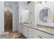 Bathroom featuring double sinks, granite countertops, a linen closet, and a tiled walk-in shower at 11026 Barnsley Dr, Venice, FL 34293