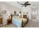 Charming bedroom with ceiling fan, carpeted floors, en-suite bathroom, and side table decor at 11026 Barnsley Dr, Venice, FL 34293