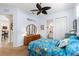 This cozy bedroom showcases the closet, bathroom entry, and decorative furnishings with ceiling fan at 11026 Barnsley Dr, Venice, FL 34293