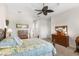 Comfortable bedroom with tray ceiling, ceiling fan, carpet floors, and a view to the en-suite bathroom at 11026 Barnsley Dr, Venice, FL 34293