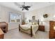 Cozy bedroom features a tray ceiling with ceiling fan, and ample natural light from the window at 11026 Barnsley Dr, Venice, FL 34293