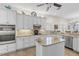 Well-lit kitchen with white cabinets, stainless steel appliances, granite counters, and kitchen island at 11026 Barnsley Dr, Venice, FL 34293