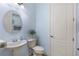 This powder room showcases updated faucet, blue paint, and decorative mirror at 11026 Barnsley Dr, Venice, FL 34293
