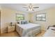 Bright bedroom with a comfortable bed, ceiling fan, hardwood floors, and natural light at 11153 Deerwood Ave, Englewood, FL 34224