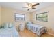 Bright bedroom with two twin beds, ceiling fan, wood floors, and natural light at 11153 Deerwood Ave, Englewood, FL 34224