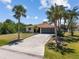 Inviting single-story home with a two car garage, palm trees, and a well-maintained driveway at 11153 Deerwood Ave, Englewood, FL 34224