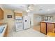Well-lit kitchen with white appliances, tile floors, and ceiling fan is adjacent to the dining area at 11153 Deerwood Ave, Englewood, FL 34224