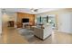 Cozy living room features comfortable seating, a wood accent wall, and sliding door to a screened patio at 11153 Deerwood Ave, Englewood, FL 34224