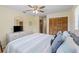 Serene primary bedroom with a ceiling fan, spacious closet, and a large dresser with a TV at 11153 Deerwood Ave, Englewood, FL 34224
