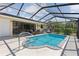 Relaxing screened-in pool area with comfortable seating and a well-maintained in-ground pool at 11153 Deerwood Ave, Englewood, FL 34224